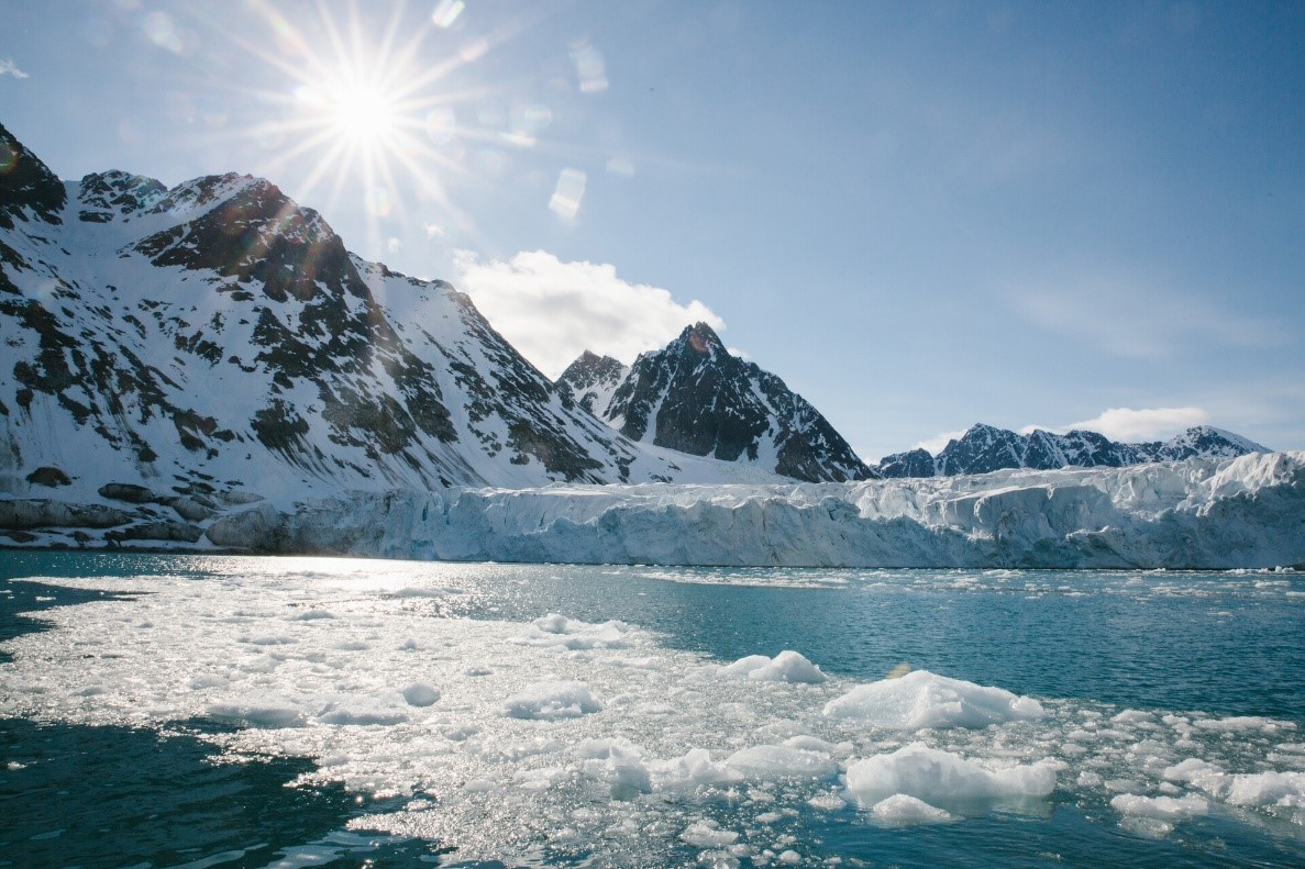 Sunlit glacier front and brash ice in a polar fjord